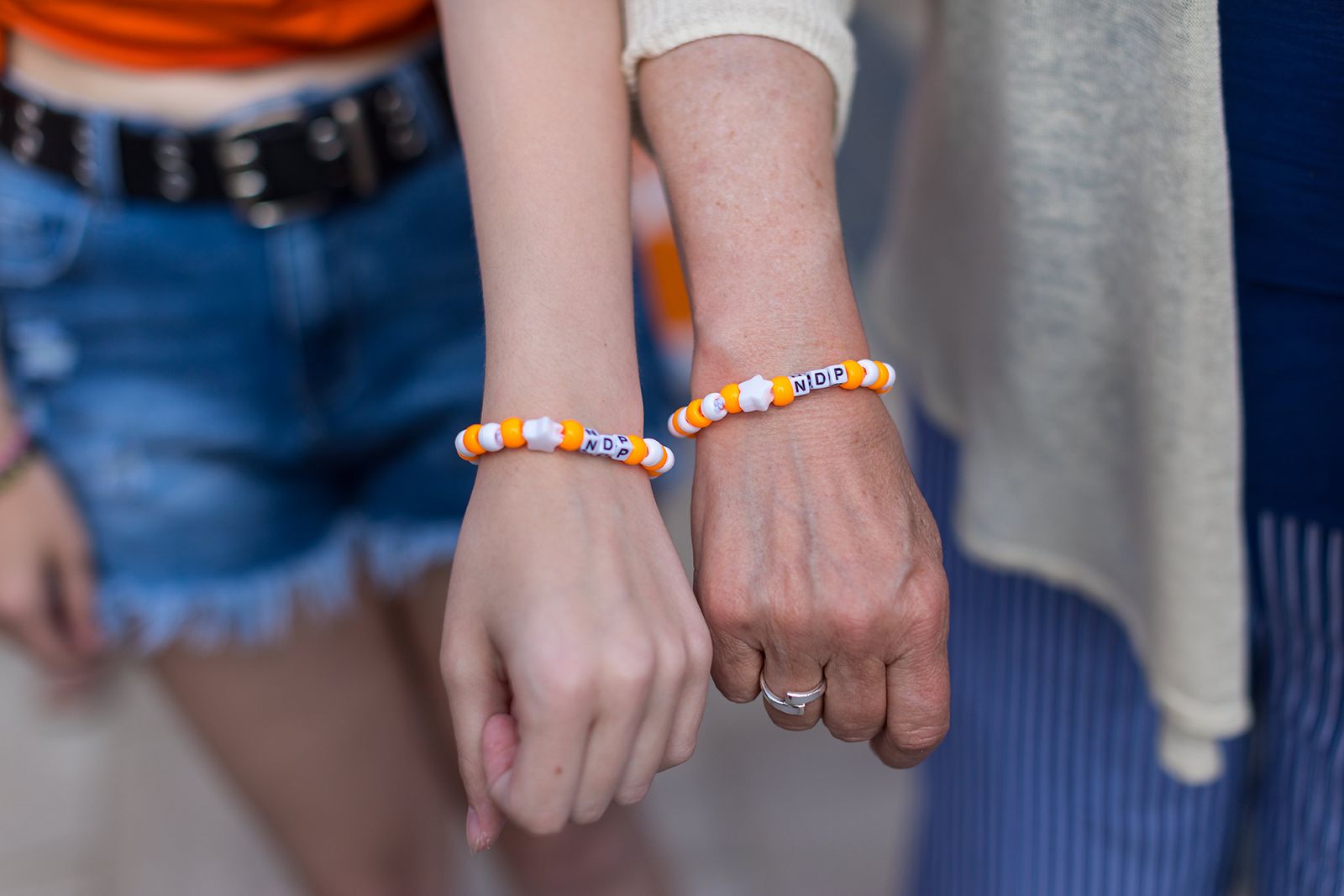 Two people wearing NDP bracelets
